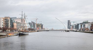 Dublin, İrlanda - 12 Şubat 2019: 3 direkli yelkenli Jeanie Johnston ve Samuel Beckett köprüsünün kopyasıyla şehir merkezinde Liffey Nehri manzarası