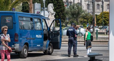 Lizbon, Portekiz - 7 Mayıs 2018: Bir bahar günü Portekiz 'in tarihi şehir merkezinde yoldan geçenlerle sohbet eden bir polis memuru