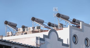 Tavira, Portekiz - 30 Nisan 2018: Bir bahar günü bir evin çatısında birçok klima ve güneş suyu ısıtıcısı