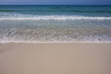 Turkuaz deniz dalga köpüğü plajda Ajman, Birleşik Arap Emirlikleri