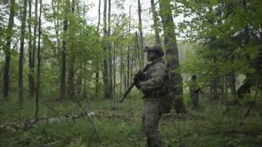 Askerleri ormana doğru git. Yeşil çalılıkları için gönderilen silah ile askeri. airsoft oyun