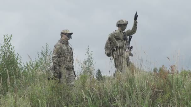 Dos militares de pie en el campo, uno de ellos bailando en la colina — Vídeo de stock