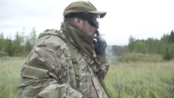 Le soldat dans les gradins et fume sur le fond de la forêt — Video