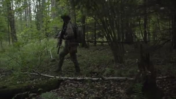 Soldaten gehen durch den Wald. Militär mit Waffen, die in das Dickicht des Grüns geschickt werden. Airsoft-Spiel — Stockvideo