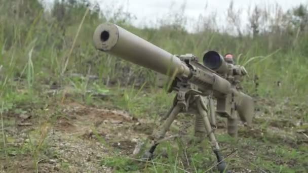 Камуфляжная снайперская винтовка лежит на земле в траве. пневматическое оружие — стоковое видео