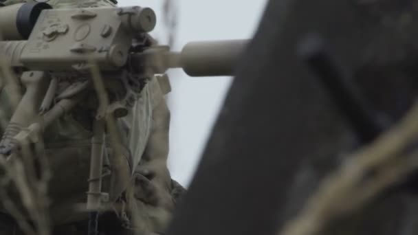 Солдат стоїть біля дерев'яного укриття зі зброєю — стокове відео