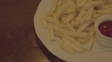 Ketçap ile bir tabak kızarmış patates. Fast food masanın üzerine sos ile