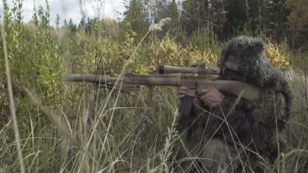 Rifle de francotirador en traje de protección sentado en un campo — Vídeos de Stock