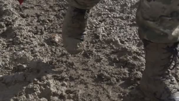 The military are on a dirt road. Dirt-Caked Boots and legs — Stock Video