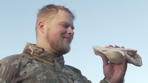 Удовлетворен тем, что военные в форме едят пиццу — стоковое видео