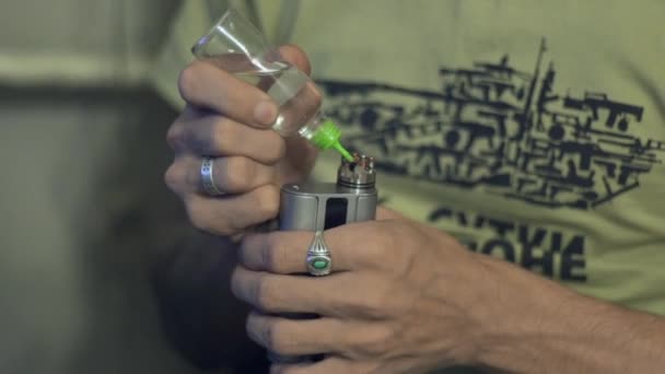 若い男は、あなたの手でそれを保持している間電子タバコを実行します。 — ストック動画