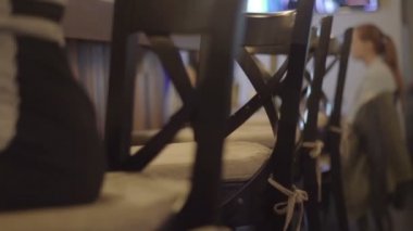 bir bar üzerinde oturan siyah elbiseli kız dışkı