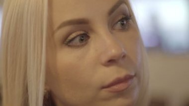 bir barda oturan genç ve güzel sarışın kız