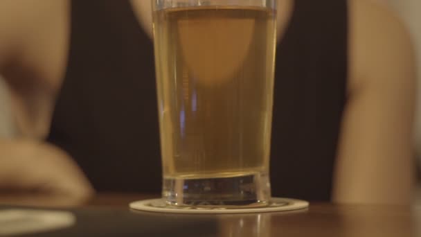 Joven rubia bebiendo un vaso de cerveza en un bar — Vídeo de stock