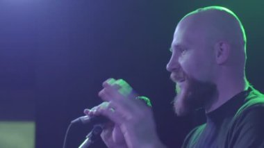 bir adam bir mikrofon önünde duruyor