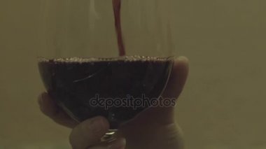 Kırmızı şarap bardağa döküldü.