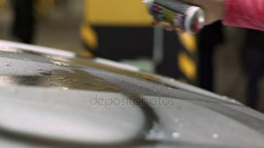 Kız bir kapsayıcı bir beyaz araba vücut üzerinde bir boya alır