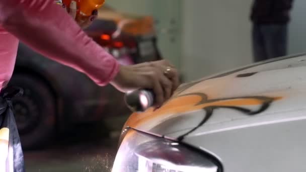 Κορίτσι παίρνει ένα χρώμα από ένα δοχείο σε ένα λευκό αυτοκίνητο σώμα — Αρχείο Βίντεο