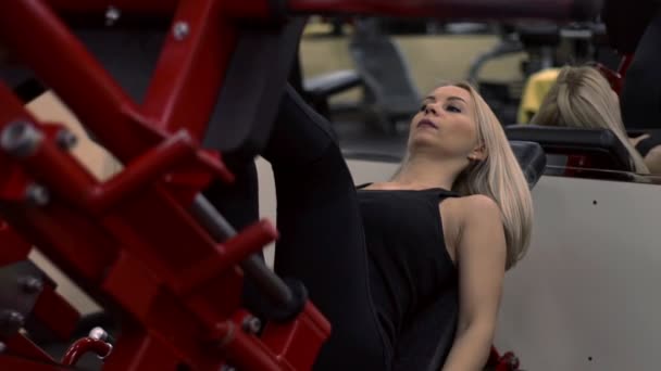 Blonde fille formation à la salle de gym. Femme engagée dans la forme physique — Video