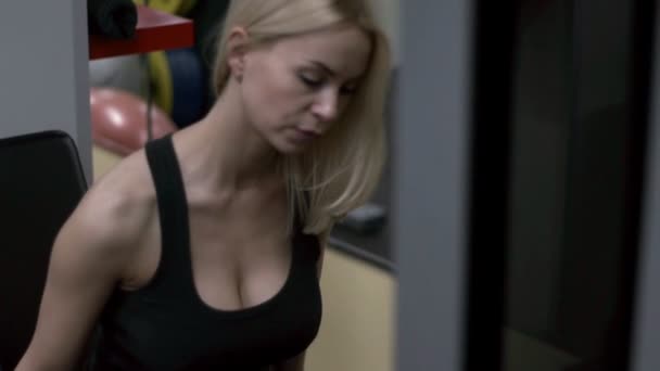 Blond meisje training op de sportschool. Vrouw die zich bezighouden met fitness — Stockvideo