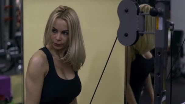 Blond meisje training op de sportschool. Vrouw die zich bezighouden met fitness — Stockvideo