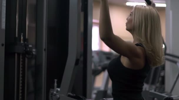 Chica rubia entrenando en el gimnasio. Mujer dedicada al fitness — Vídeos de Stock