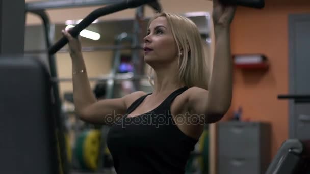 Блондинка тренується в спортзалі. Жінка займається фітнесом — стокове відео
