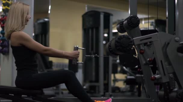 Chica rubia entrenando en el gimnasio. Mujer dedicada al fitness — Vídeos de Stock