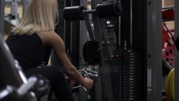 Blond meisje training op de sportschool. Vrouw die zich bezighouden met fitness — Stockvideo