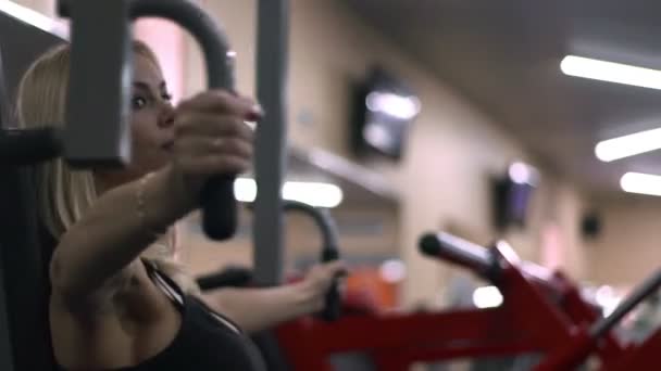 Blonde girl training at the gym. Woman engaged in fitness — Stock Video