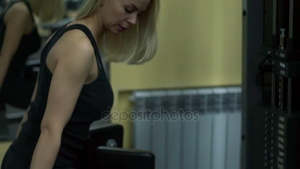 Chica rubia entrenando en el gimnasio. Mujer dedicada al fitness — Vídeo de stock