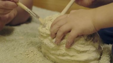 Arkeoloji oynayan aile iskelet almak için sıva yok eder. arkeolojik kazılar