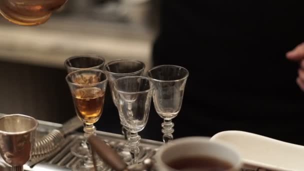 Um barman homem derrama uma bebida em copos — Vídeo de Stock