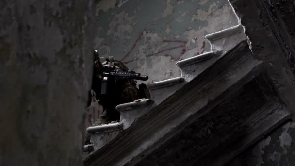 Военные с оружием защищают здание и поднимаются по лестнице. — стоковое видео