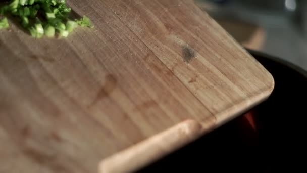 Cuchillo en un tazón de perejil picado sobre tabla de madera. Preparación de ensaladas — Vídeo de stock