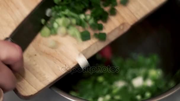 With a knife chopped green onion on wooden board. Food ingredients salad — Stock Video