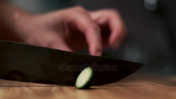 여성 손 나무 보드에 칼으로 오이 잘라. 샐러드 재료. — 비디오