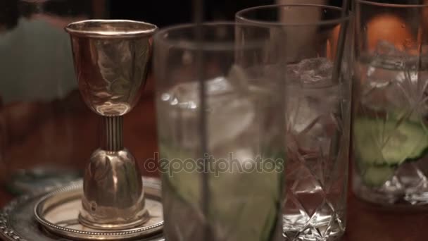 Un vaso de jarabe gotea en las copas de vidrio con un cóctel. Preparación de cócteles en bar — Vídeos de Stock