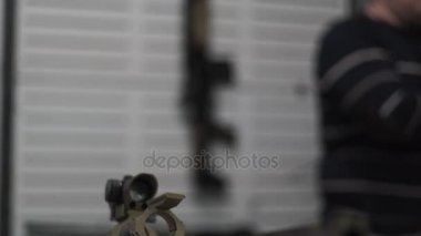 Keskin nişancı tüfeği ile bir optik görüş çuval üzerinde duruyor. Askeri kamuflaj tüfek