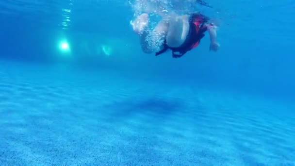 Los niños nadan en la piscina bajo el agua en cámara lenta — Vídeos de Stock