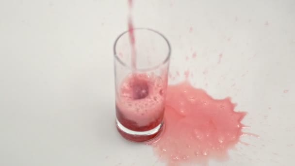 Boisson carbonatée rouge versée dans du verre sur fond blanc. Verre avec boisson rouge — Video