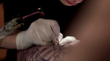 Dövmeci dövme salonunda bir istemciye dövme