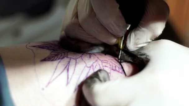 Tatuagem tatuadora faz tatuagem de um cliente com uma máquina de tatuagem — Vídeo de Stock