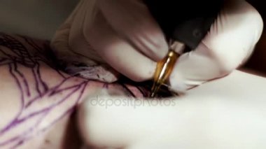 Dövmeci dövme makinesi ile bir istemci dövme