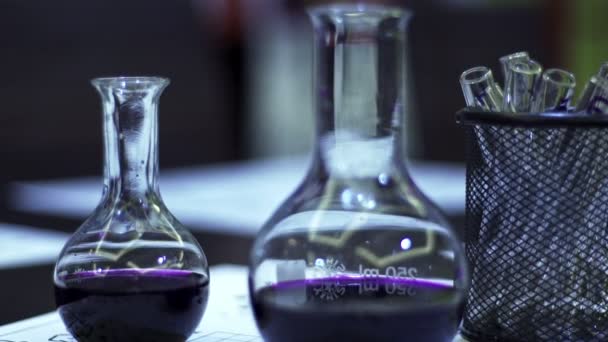 Glass flasks with colored liquid in a chemical laboratory. Chemical research — Stock Video