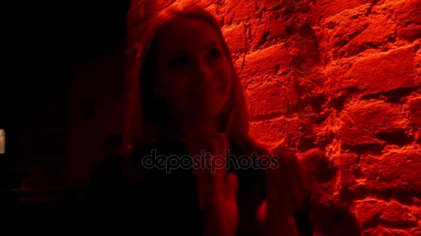 Портрет молодой женщины, хлопающей в ладоши на музыкальном концерте на фоне красного освещения — стоковое видео