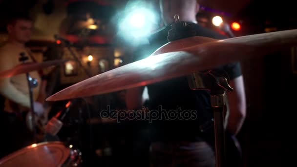Рок-музикант грає на електрогітарі на фоні барабанної пластини на концертній сцені — стокове відео