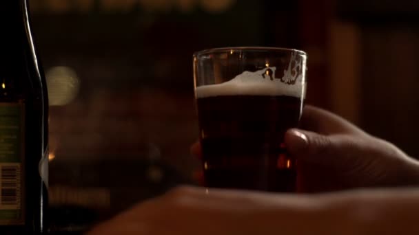 Szklanka do piwa na stole. Ręka dotyka szklanka piwa i biorąc na drinka — Wideo stockowe