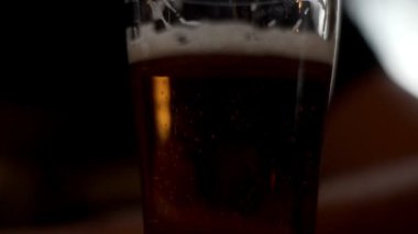 Bira cam masa üzerinde duran. Adam el cam bira içecek için pub bar alarak