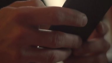 Cep telefonu kullanan adam kapatın. Adam ellerini tipik haber ekran smartphone